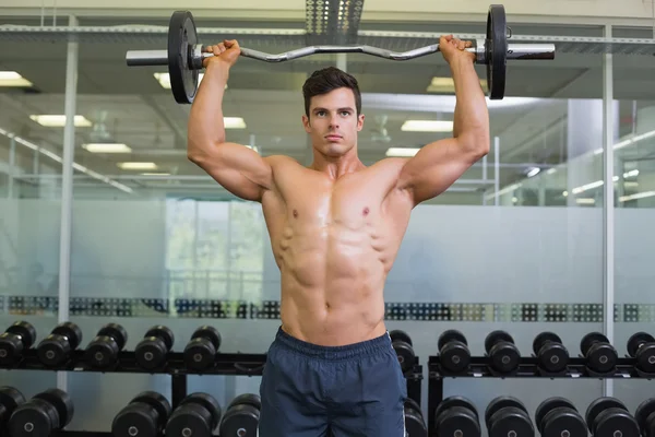 Hombre musculoso sin camisa levantando barra en el gimnasio —  Fotos de Stock