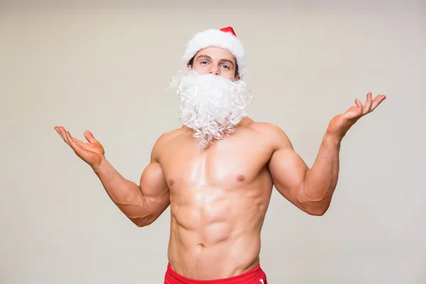 Portret van shirtloze macho man met nep kerstman baard — Stockfoto