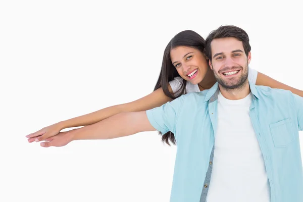 Happy casual man giving pretty girlfriend piggy back — Stock Photo, Image