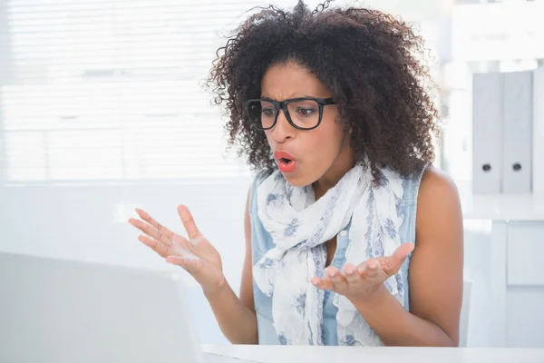 Hipster estressado trabalhando em sua mesa com laptop — Fotografia de Stock