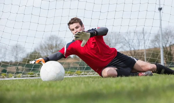 Goalkeeper in red saving a goal during a game — Stock Photo, Image