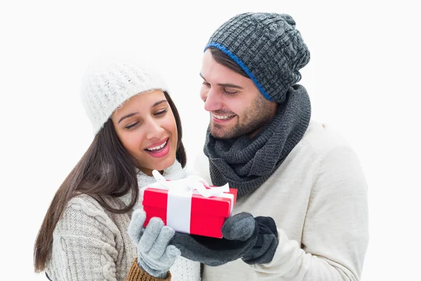 Atraente jovem casal em roupas quentes segurando presente — Fotografia de Stock