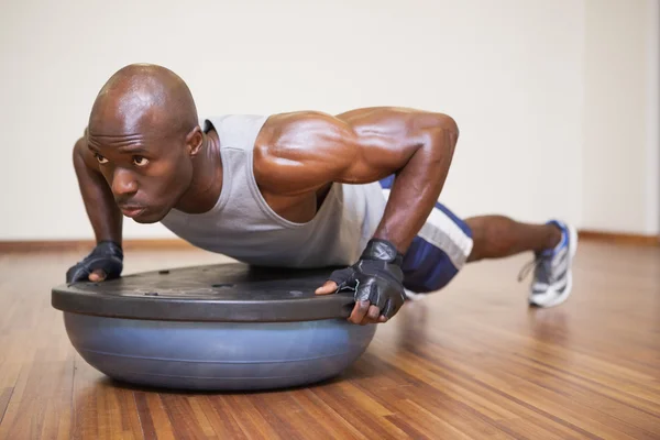 Muscular man doing push ups in gym — Stock Photo, Image