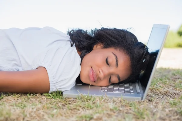 Mujer acostada en la hierba durmiendo en su portátil — Foto de Stock