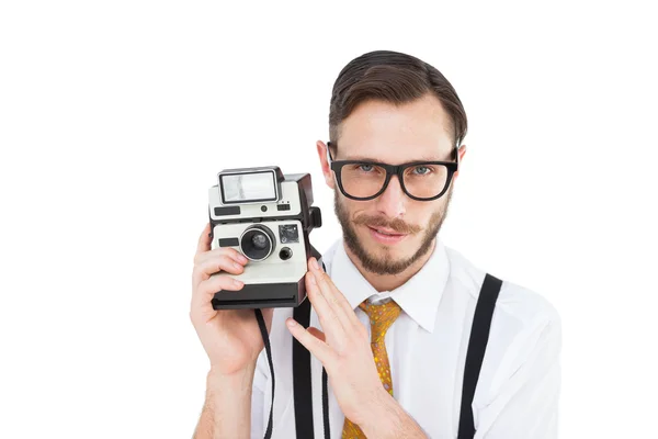 Geeky hipster holding a retro camera — Stock Photo, Image