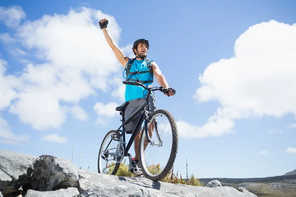 男は岩の多い地形上の自転車と応援 — ストック写真