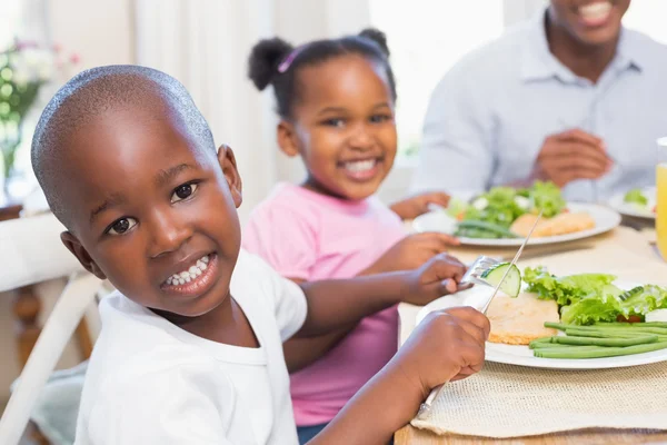 Family enjoying a healthy meal together with son smiling at came — Stock Photo, Image