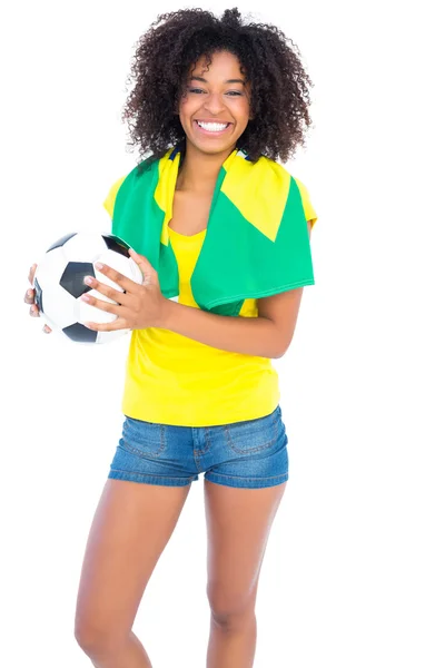 Bastante aficionado al fútbol con bandera brasileña sonriendo a la cámara — Foto de Stock