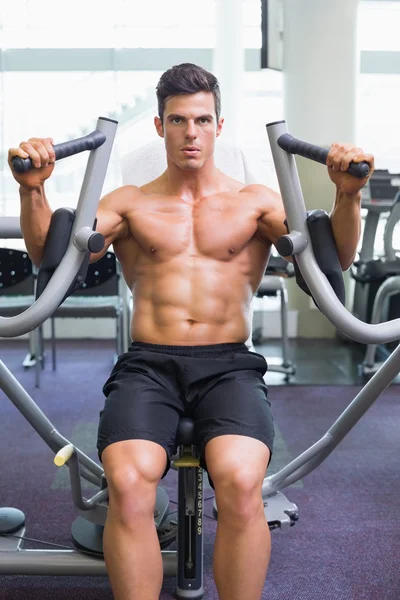 肌肉男在健身房健身机上工作 — 图库照片