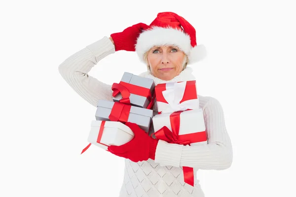 Mulher festiva coçando cabeça e segurando presentes — Fotografia de Stock