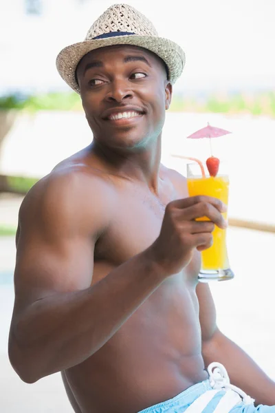 Homem sorridente em calções de banho segurando um coquetel — Fotografia de Stock