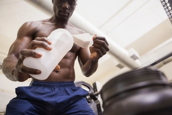 Body builder scooping up protein powder — Stock Photo, Image