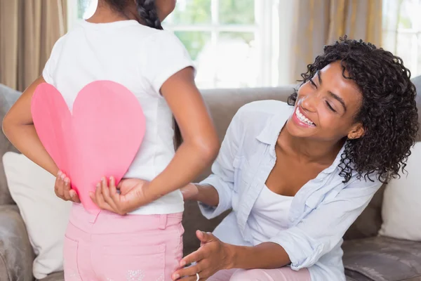 Bonita madre con hija escondiendo tarjeta de corazón —  Fotos de Stock