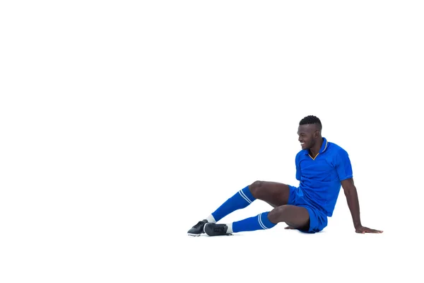 Piłkarz w niebieski siedzący i uśmiechając się — Zdjęcie stockowe