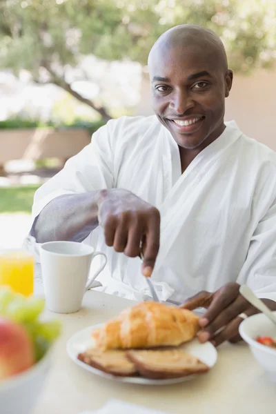 Hombre guapo en albornoz desayunando afuera — Foto de Stock