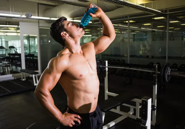 Muscular man drinking energy drink — Stock Photo, Image