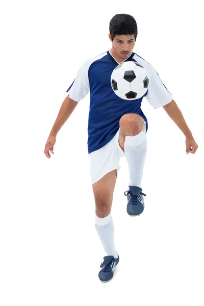 Football player in blue kicking ball — Stock Photo, Image