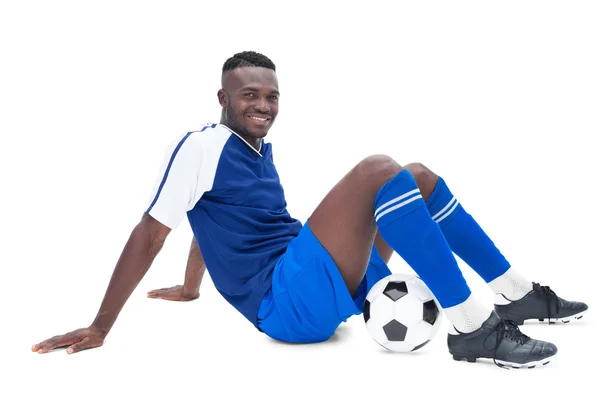 Jugador de fútbol en azul sentado con pelota —  Fotos de Stock