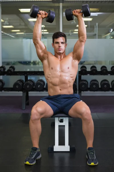 Muskularny mężczyzna ćwiczenia z hantlami w siłowni — Zdjęcie stockowe