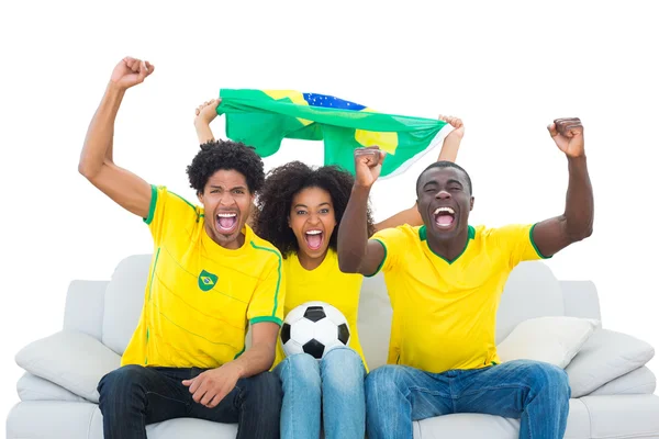 Glada fotbollsfans i gult med Brasilien flagga — Stockfoto