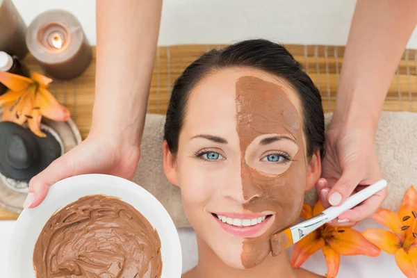 Vreedzame brunette krijgen een modder gezicht toegepast — Stockfoto