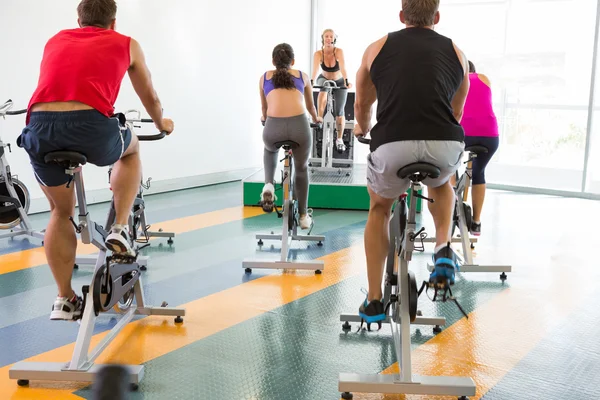 Spin klasse uit te werken met motiverende instructeur — Stockfoto