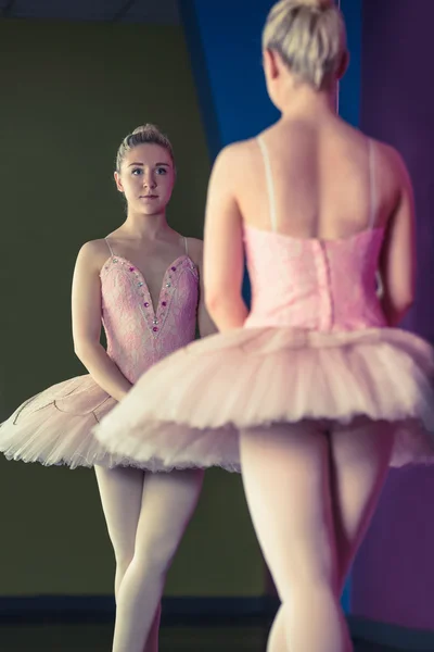 Anmutige Ballerina steht an erster Stelle vor dem Spiegel — Stockfoto