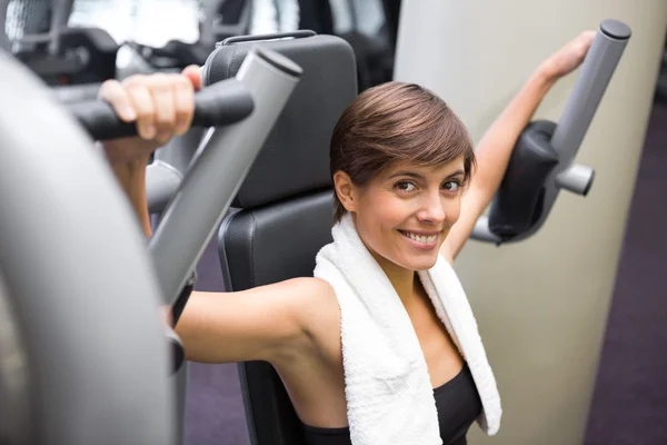 Glückliche Brünette mit Gewichten Maschine für Arme — Stockfoto