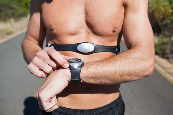 Sportlicher Mann auf offener Straße mit Monitor um die Brust — Stockfoto