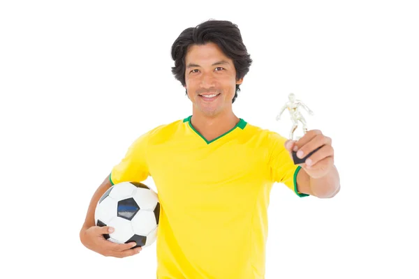 Jogador de futebol em amarelo segurando vencedores troféu — Fotografia de Stock