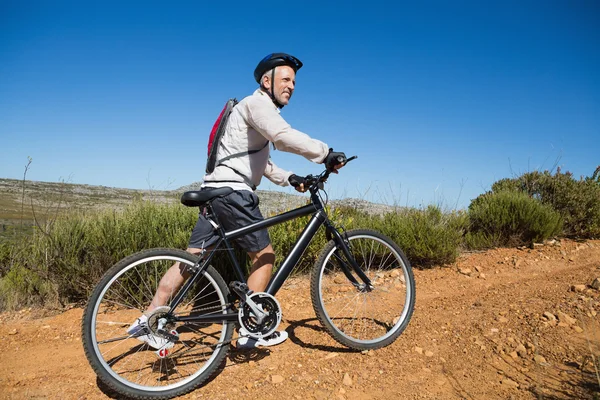 Fit cycliste poussant vélo vers le haut sur le terrain de campagne — Photo