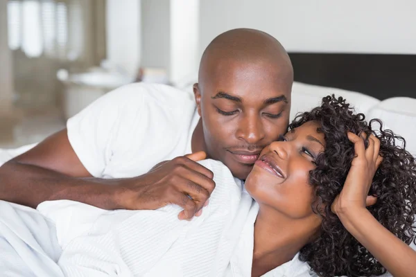 Happy couple lying in bed together — Stock Photo, Image