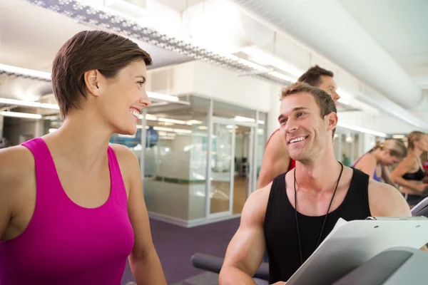 Trainer talking to his client on the treadmill — Stock Photo, Image