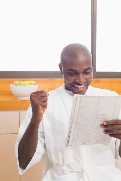 Happy man in bathrobe reading newspaper — Stock Photo, Image