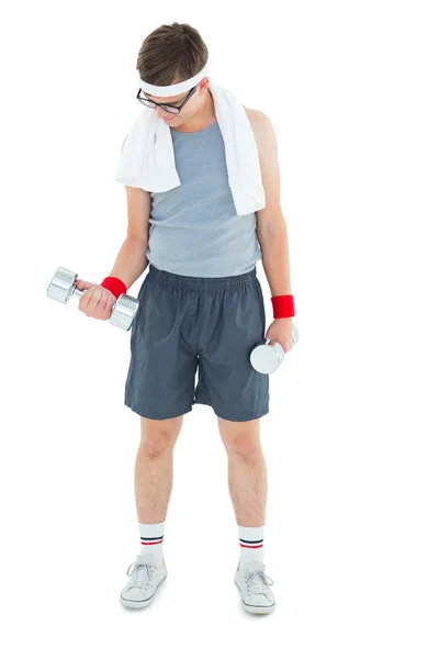 Geeky hipster lifting dumbbells in sportswear — Stock Photo, Image