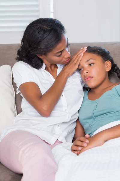 Besorgte Mutter berührt ihre Töchter an der Stirn — Stockfoto