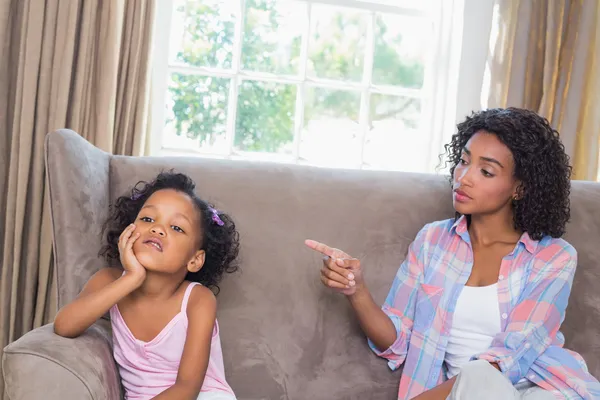 Hübsche Mutter schimpft ihre Tochter auf der Couch — Stockfoto