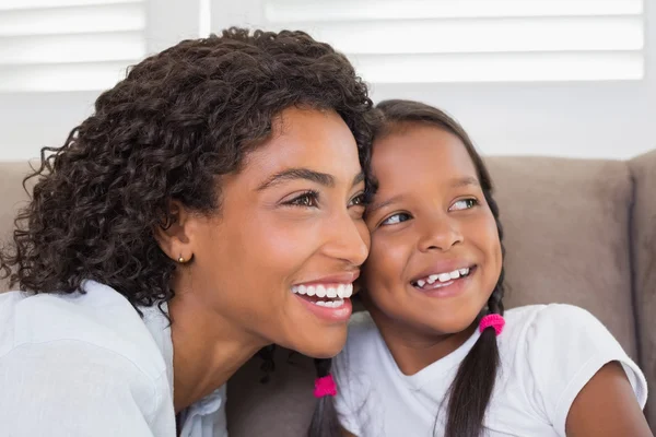 Bonita madre sentada en el sofá con su hija — Foto de Stock