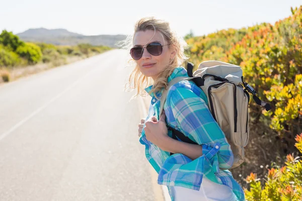 Blonde hitch hiking on rural road — Stock Photo, Image