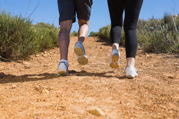 Pareja en forma trotando por sendero de montaña —  Fotos de Stock