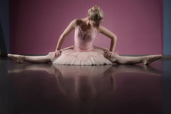 Gracieuze ballerina zittend met benen gestrekt — Zdjęcie stockowe