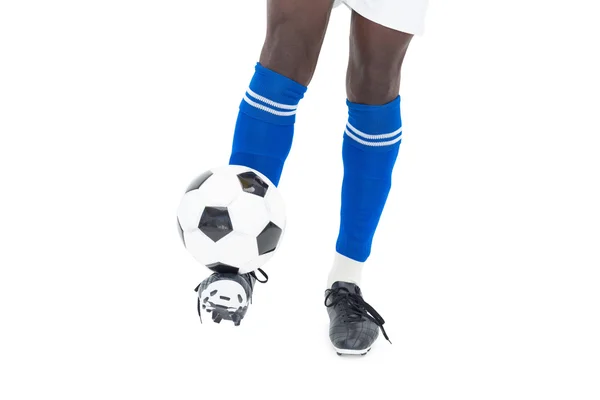 Football player in blue socks kicking ball — Stock Photo, Image