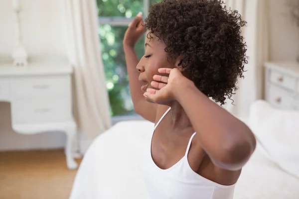 Hübsche Frau sitzt gähnend im Bett — Stockfoto