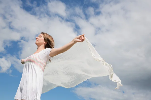 Mujer sosteniendo bufanda contra el cielo azul y las nubes —  Fotos de Stock