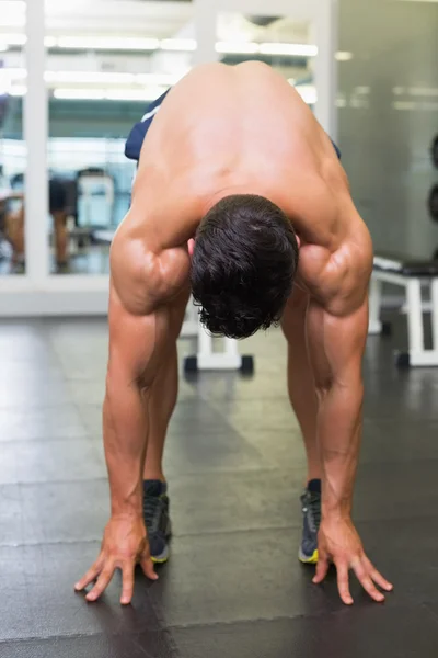 Hombre musculoso sin camisa flexión en el gimnasio — Foto de Stock