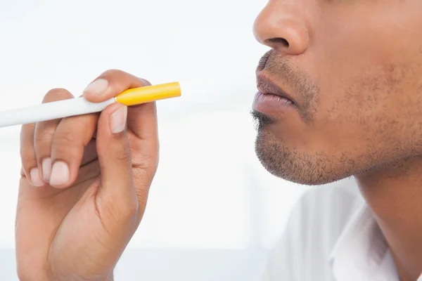Бизнесмен курит электронную сигарету — стоковое фото