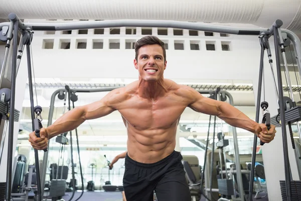 Hombre musculoso sin camisa usando banda de resistencia en el gimnasio —  Fotos de Stock