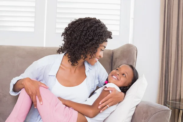 Bella madre seduta sul divano con sua figlia — Foto Stock