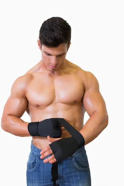 Shirtless muscular man binds bandage on his hand — Stock Photo, Image