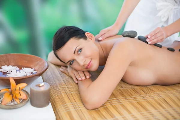 Brunette enjoying hot stone massage — Stock Photo, Image